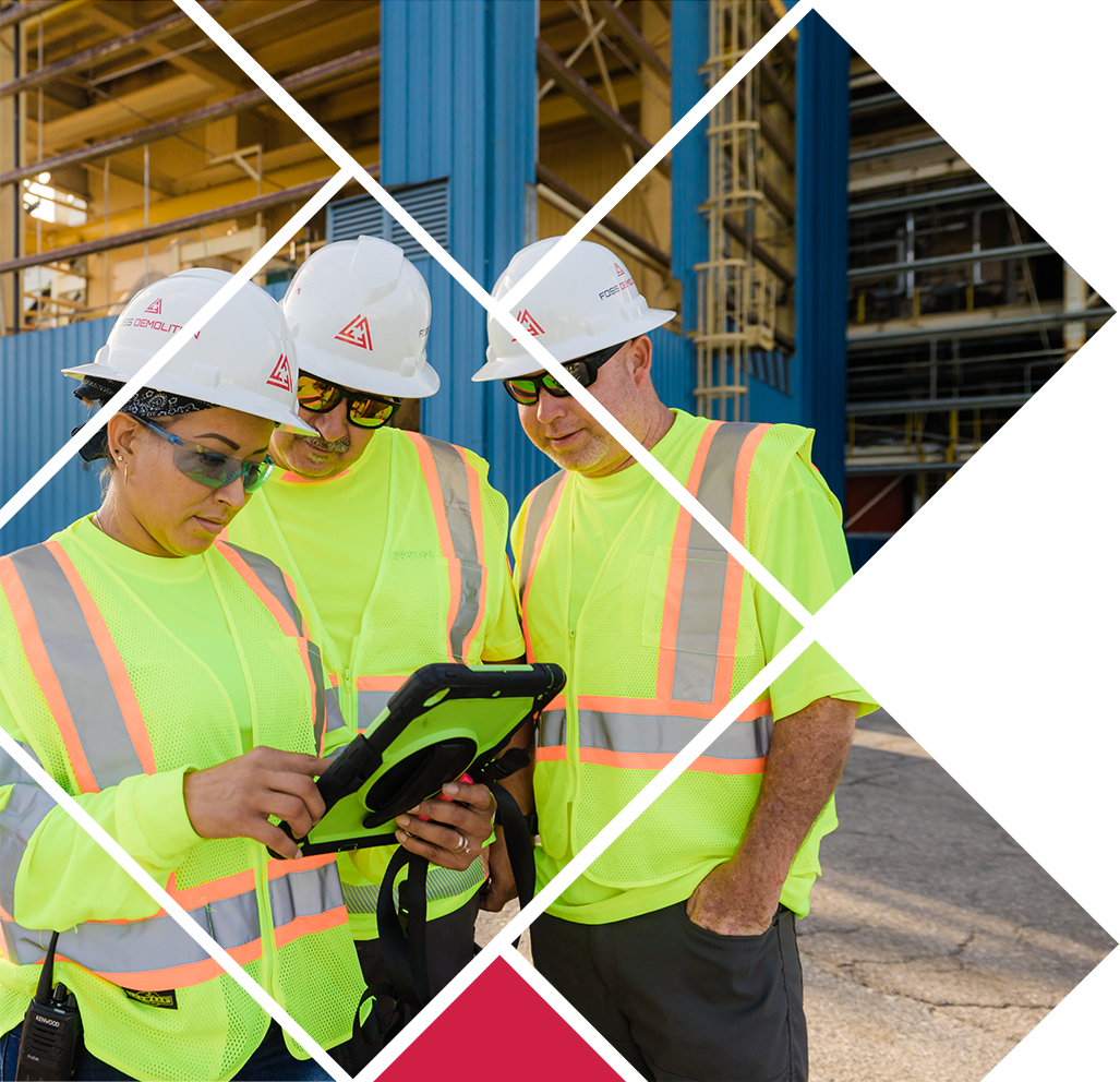 Workers wearing safety vests looking over tablet