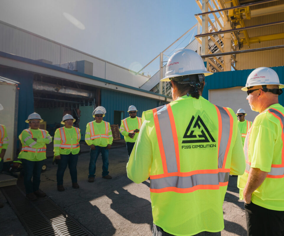 Workers meeting outside wearing safety vests